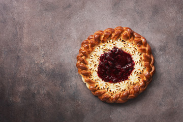 Cottage cheese pie with strawberry jam on a dark rustic background. Top view, flat lay, copy space.