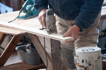 Using a jigsaw to cut a cruve in a piece of wood.
