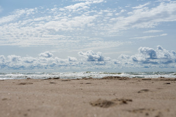 Beautiful view of wavy sea on a sunny day with dramatic clouds. Vacation and holidays background, global warming and climate change concept
