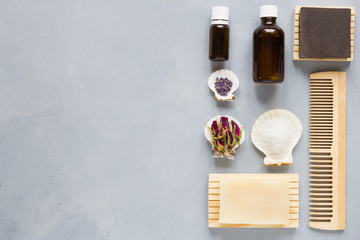 Aromatic spa set products with soap, essential oil and herbs on gray background. flat lay, with copy space