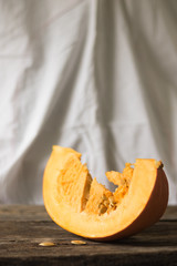 Fresh pumpkin on the table from old boards. Vertical orientation and white background.