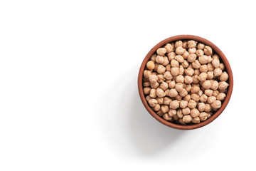 Raw chickpeas in a clay ceramic bowl on a white background, isolated, top view.