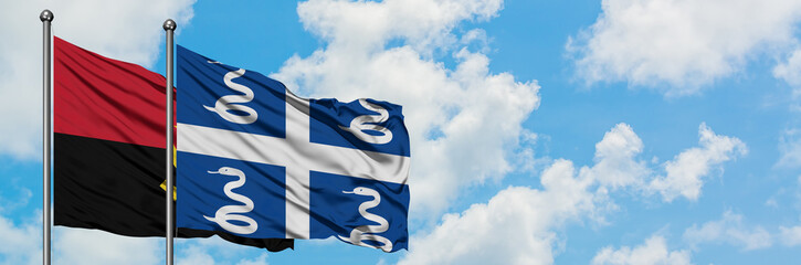 Angola and Martinique flag waving in the wind against white cloudy blue sky together. Diplomacy concept, international relations.