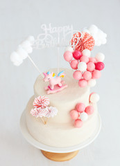baby girl birthday cake with unicorn and balloons