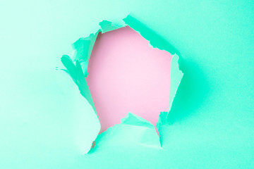 Breakthrough green paper hole. Inside is pastel pink. Minimalistic concept, bright colors, place for text. Creative design.