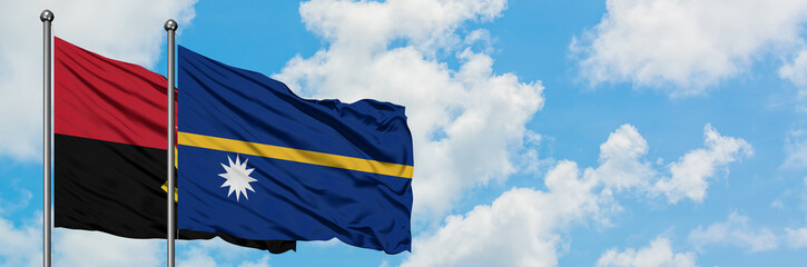 Angola and Nauru flag waving in the wind against white cloudy blue sky together. Diplomacy concept, international relations.