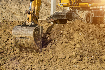 Working Excavator Tractor Digging A Trench At Construction Site.Close-up of a construction site excavator