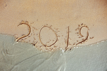 blue Wave Washing Away 2019 Year Handwritten On Sandy Beach inscription