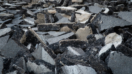 Background old cracked asphalt road scrap heap damage on the ground to be recycled.