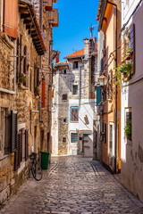Fototapeta na wymiar Narrow stone street with old stone houses in romantic Town of Rovinj, Istra, Croatia