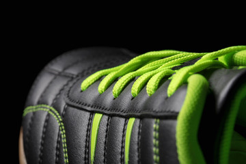 Fragment of a black sneaker closeup. Part of leather sports shoes