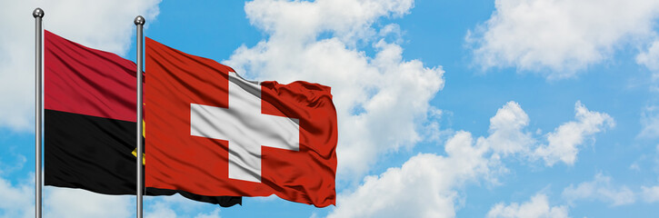 Angola and Switzerland flag waving in the wind against white cloudy blue sky together. Diplomacy concept, international relations.
