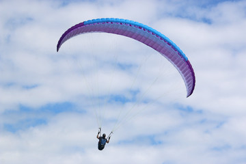 Paraglider flying wing in a blue sky