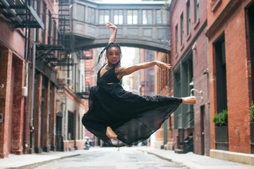Dancer facing forward mid leap above ground