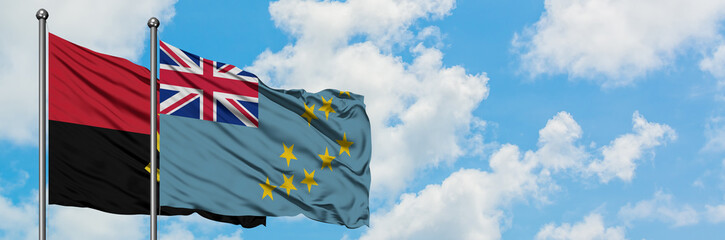 Fototapeta premium Angola and Tuvalu flag waving in the wind against white cloudy blue sky together. Diplomacy concept, international relations.