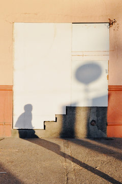 Shadow of man and balloon on wall