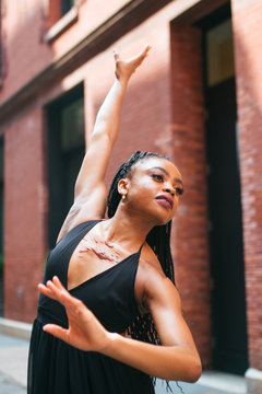 Dancer posing with right arm outstretched and left arm bent