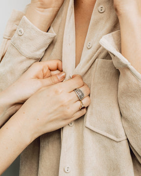 Close up view of midsection of woman buttoning shirt