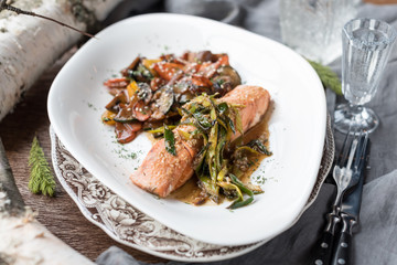 Pan Seared Salmon Steak with Sauteed Vegetables, Greens and Spicy Sauce.