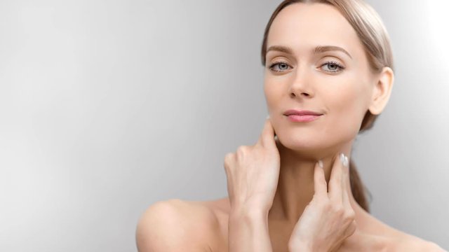Close-up naked sexy woman with perfect skin turning head posing isolated at white studio background