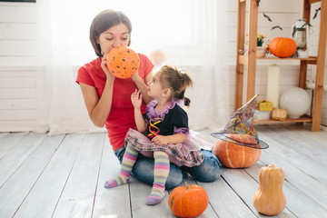 Fototapeta premium Happy family of mother and children prepare for Halloween in decorate the home