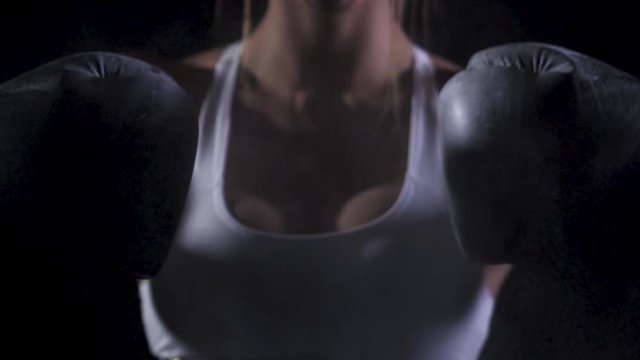 Young woman exercising at the gym in black background