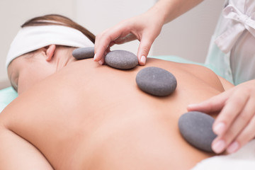 Portrait of a young woman blissfully enjoying spa therapy. close-up. Massage stones