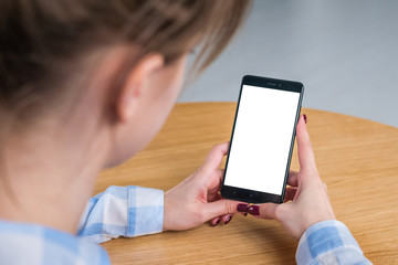 Mock up, copyspace, template and technology concept. Woman looking at black smartphone with white blank screen. Close up view of woman hands with smart phone mobile device - mockup image