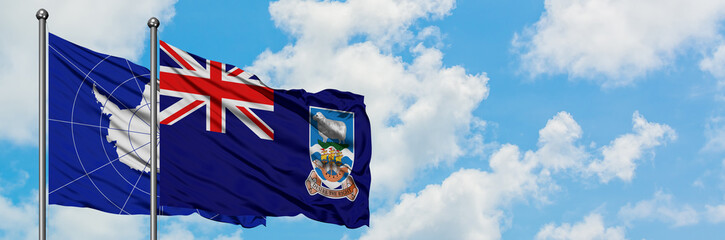 Antarctica and Falkland Islands flag waving in the wind against white cloudy blue sky together. Diplomacy concept, international relations.