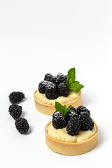 homemade Tart (tartlet) with blackberry and delicate cream of vanilla and mint
