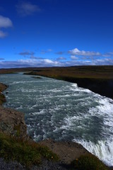 Cascada Gullfoss en Islandia vista alta con cielo azul y prados verdes