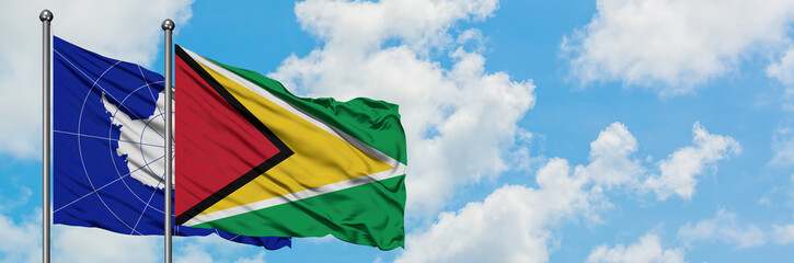 Fototapeta na wymiar Antarctica and Guyana flag waving in the wind against white cloudy blue sky together. Diplomacy concept, international relations.