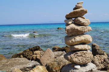 Fototapeta na wymiar tower of rocks on the coast sea among the waves
