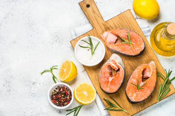 Raw salmon steak on white top view.