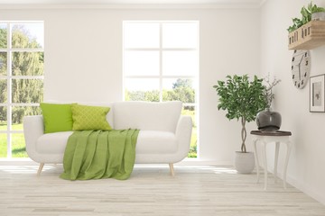 Fototapeta premium Stylish room in white color with sofa and summer landscape in window. Scandinavian interior design. 3D illustration