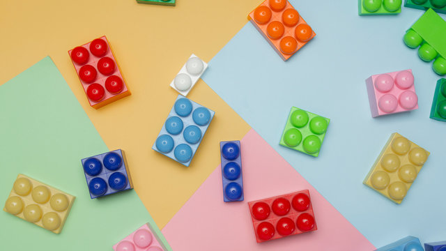 Top view of plastic blocks on colored background. Flat lay image of toy background made with color building blocks from child constructor.