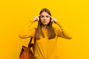 young pretty woman with a serious and concentrated look, brainstorming and thinking about a...