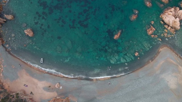 aerial 4k drone view of scenic amazing  beach cove, rocks cliff a boat and sandy beach - cala tinnari, costa paradiso - sardinia italy