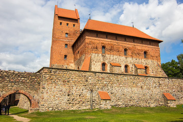Obraz premium Beautiful medieval gothic Trakai Island Castle with stone walls and towers with red tiled roofs, lake Galve, Lithuania. Main Lithuanian landmark