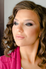 Naklejka premium beautiful young brunette girl with professional full make up looking away from camera, studio shoot close up 