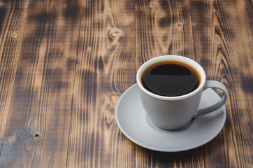 Grey cup with black coffee on on dark wooden table. Selective focus and copy space. Coffee break.