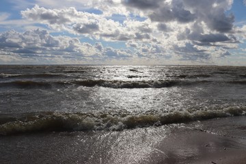 blue sky with clouds over the sea and a sunny path on the water