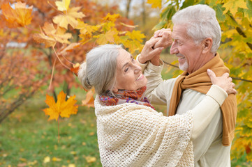 Close up portrait of happy senior couple in autumn park