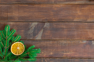 Christmas composition on wooden background with green pine and dry orange. Image with copy space, top view