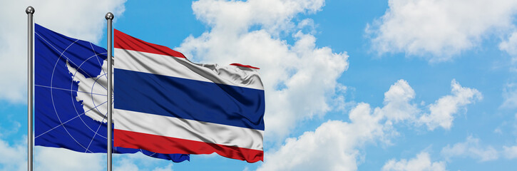 Antarctica and Thailand flag waving in the wind against white cloudy blue sky together. Diplomacy concept, international relations.