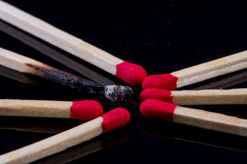 burned match with other matches with red head