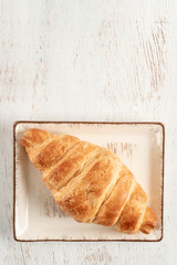 Crispy and delicious croissants on a wooden table