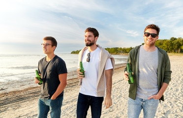 friendship and leisure concept - group of happy young men or male friends toasting non alcoholic beer walking along summer beach