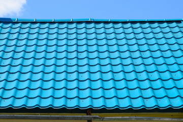 Turquoise metal tiles on roof of the house. Modern roofing materials