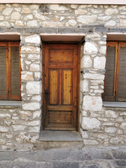 Fototapeta na wymiar Brown vintage rustic wooden door with stone wall